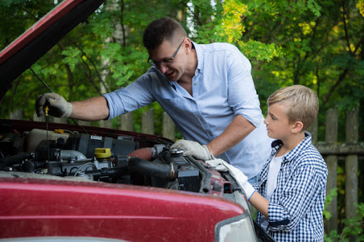 father and son working on car repairs together