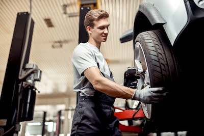 auto mechanic performing a tire rotation service