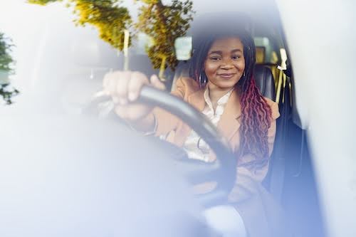 smiling woman driving her car after auto repairs